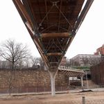 The bridge is made of wood, cables, and concrete supports